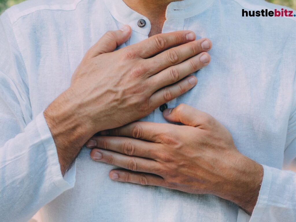 A close up of a man holding his chest.