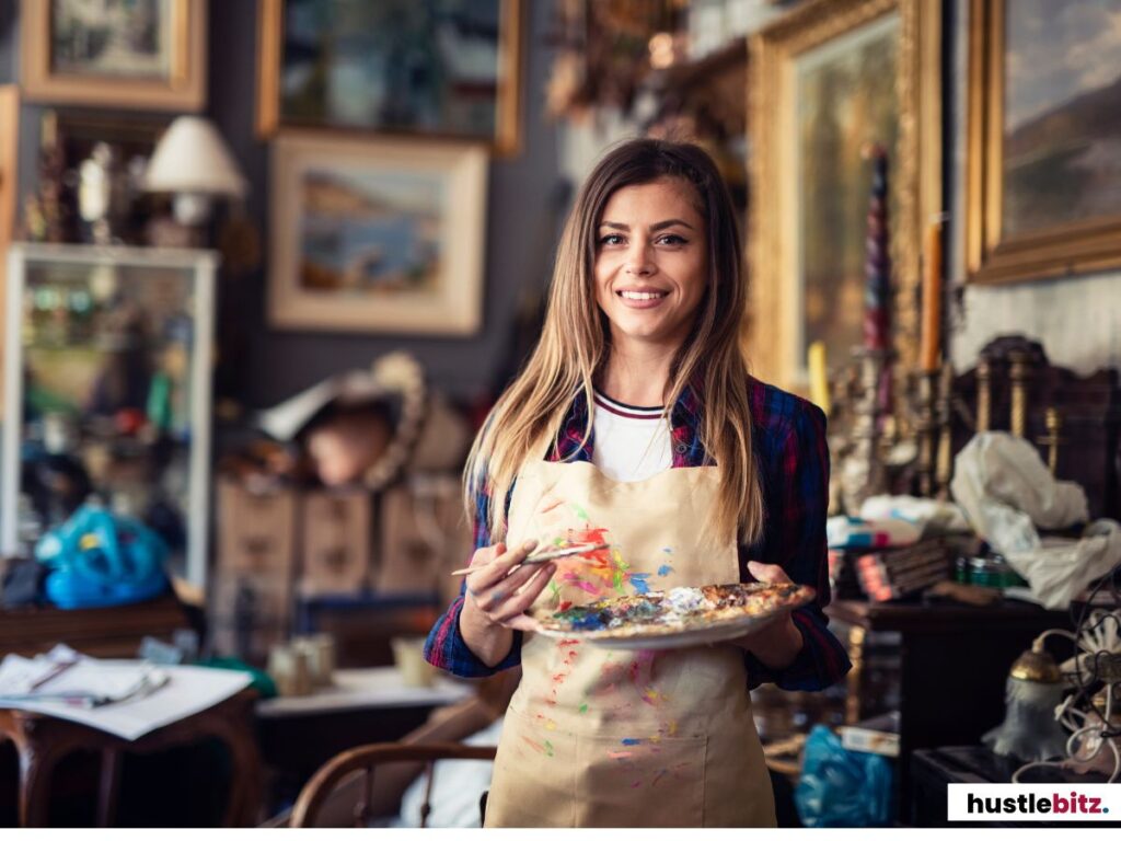 A smiling female artist holding a paint palette in a vibrant studio.