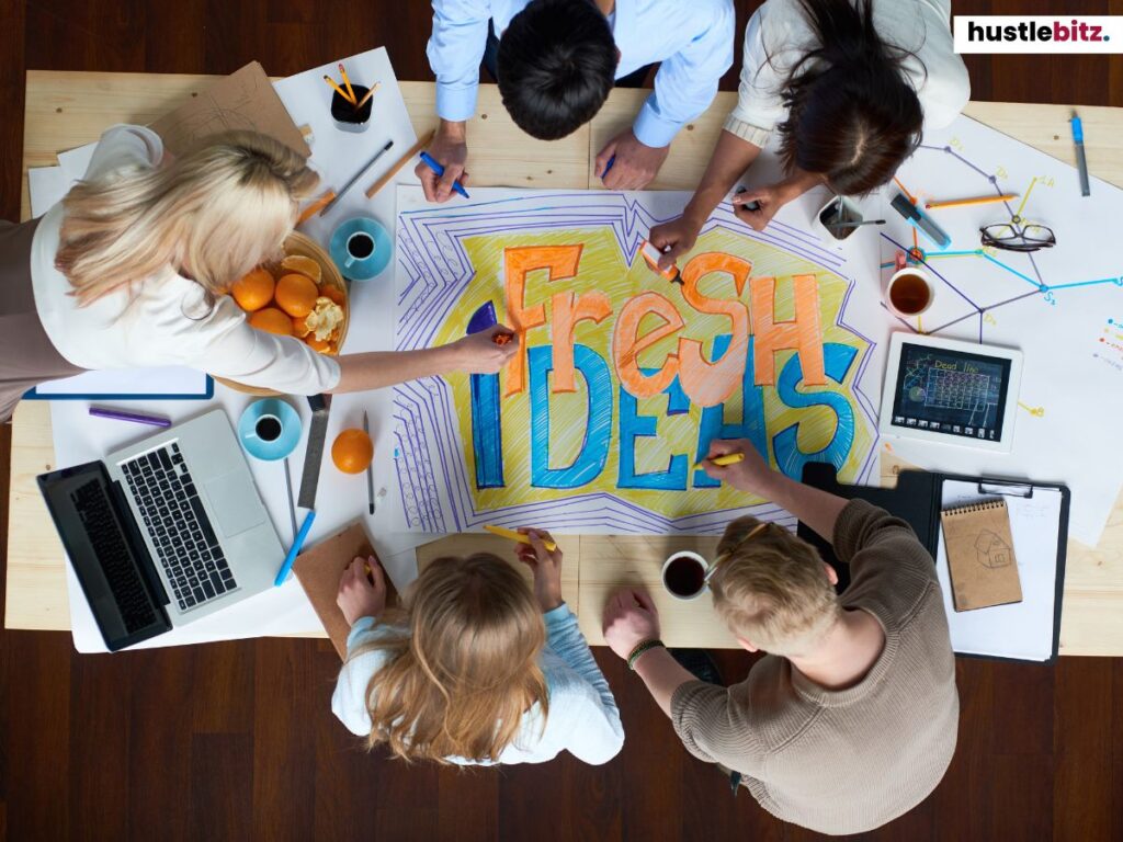 Group of people doing drawing in the table with word FRESH IDEAS