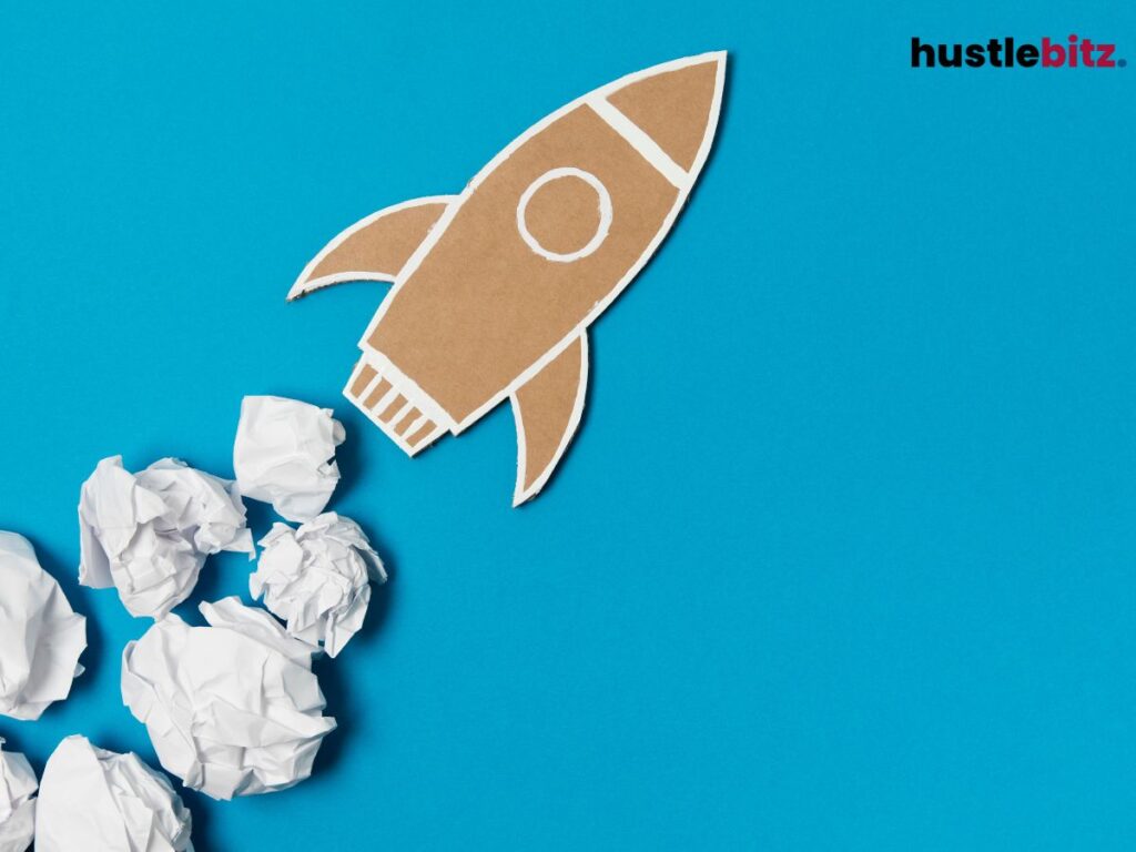 A cardboard rocket with crumpled paper as smoke against a blue background.