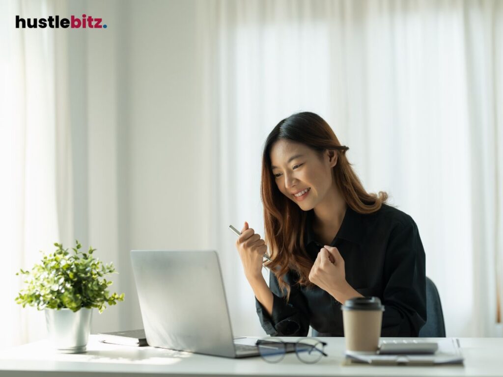 A woman smiles while looking at the laptop in the table