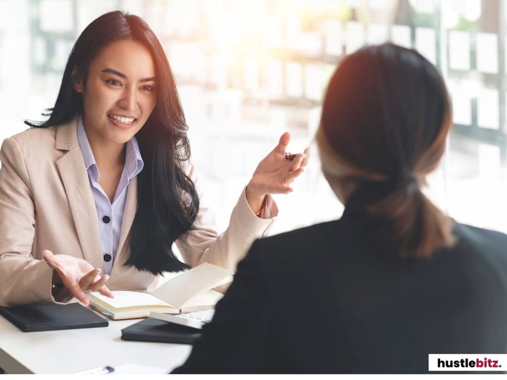 Two women in a productive business conversation with a notebook in hand.