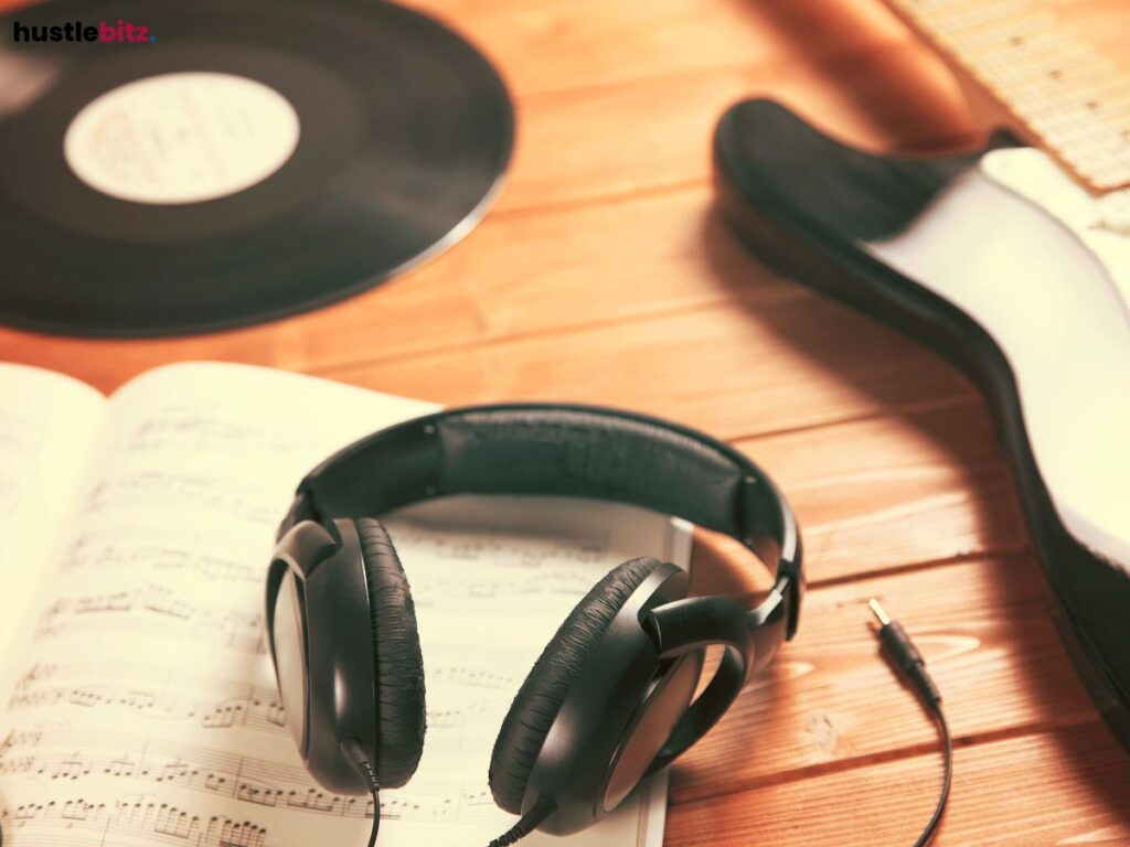 Headphones resting on sheet music with a vinyl record in the background.