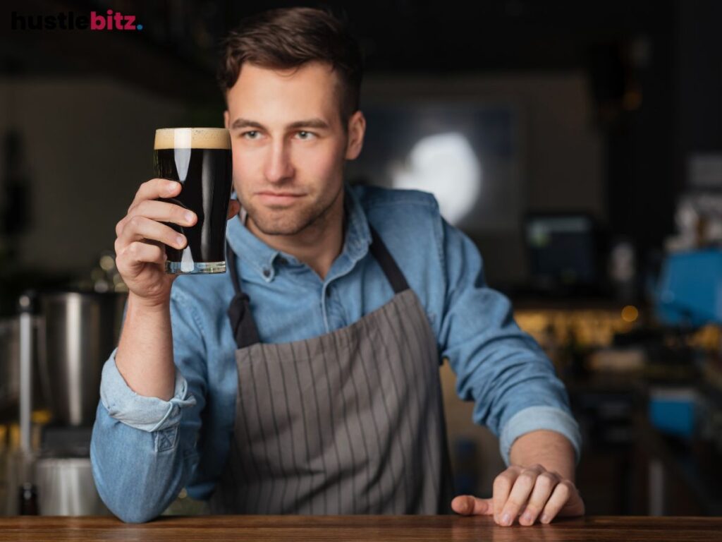 A bartender admires a dark beer, focusing on its perfect pour.