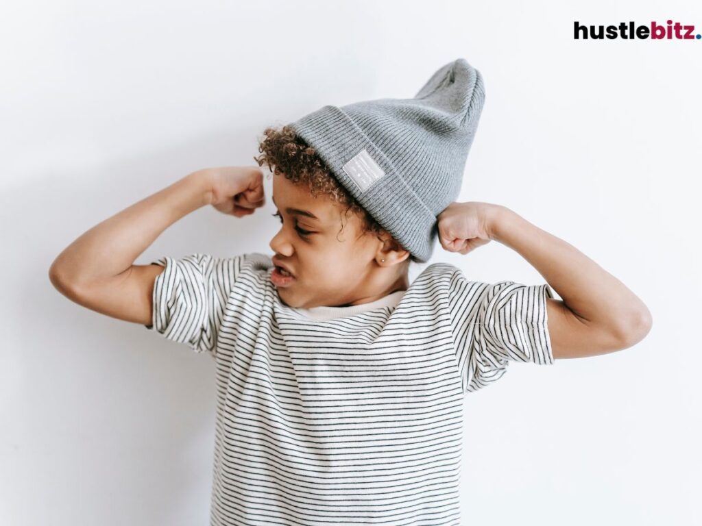 A young boy flexing his biceps.