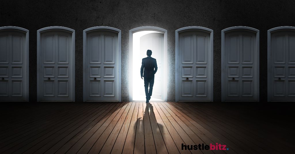 A man walks through an illuminated door among several closed ones.