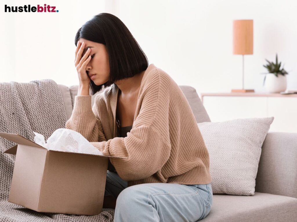 A woman sitting tap her head while looking at the box