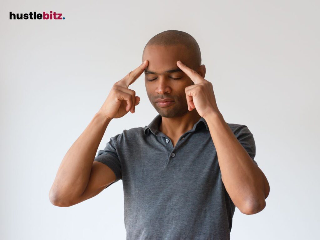 A man pointing his head and closing his eyes focusing.