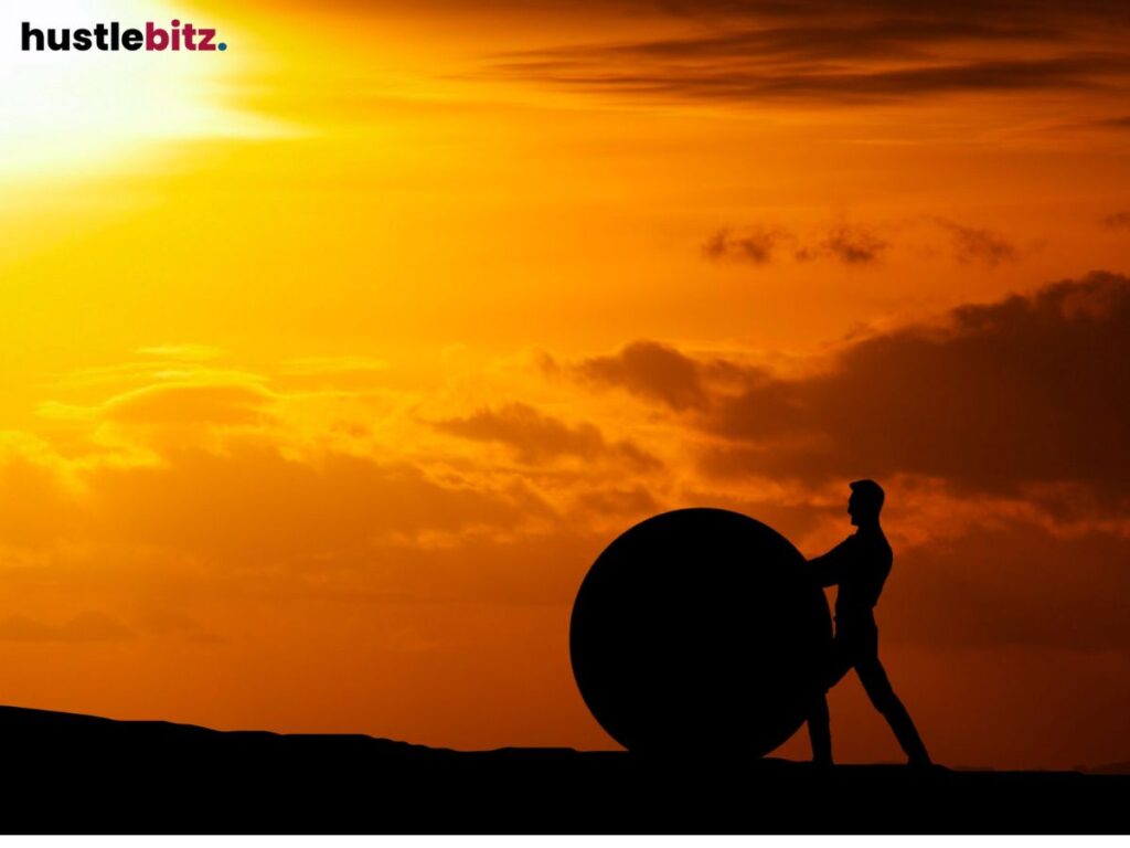 A man hold a stone circle in front of the sunset