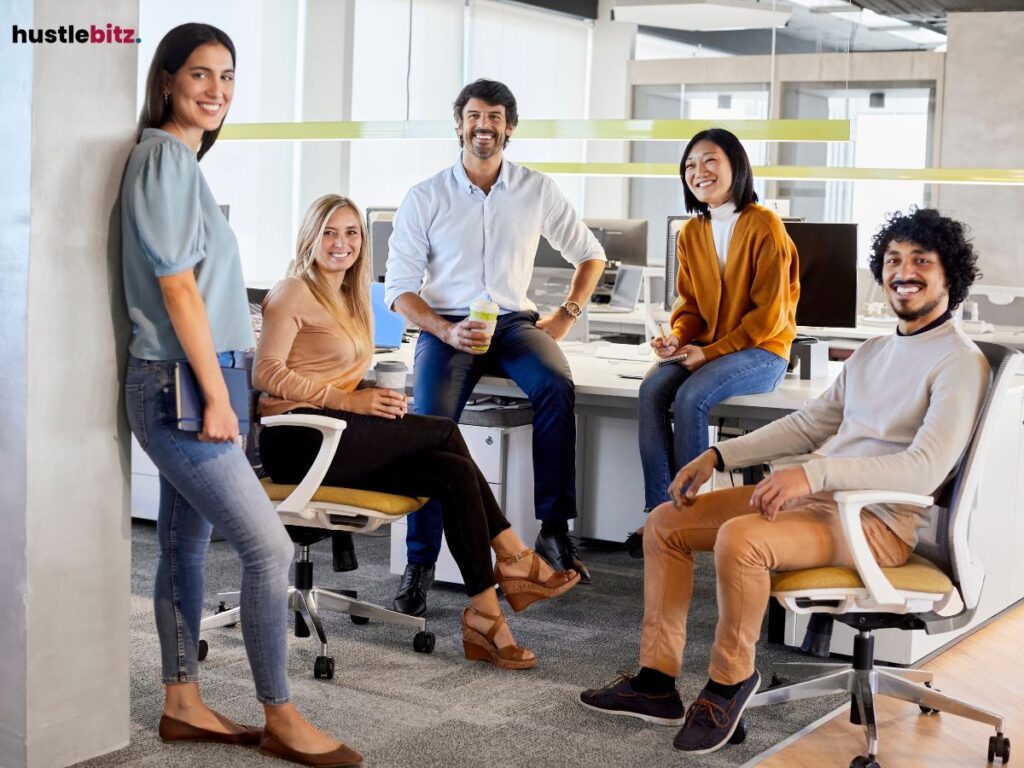 A group of people standing and sitting looking at the camera and smiles