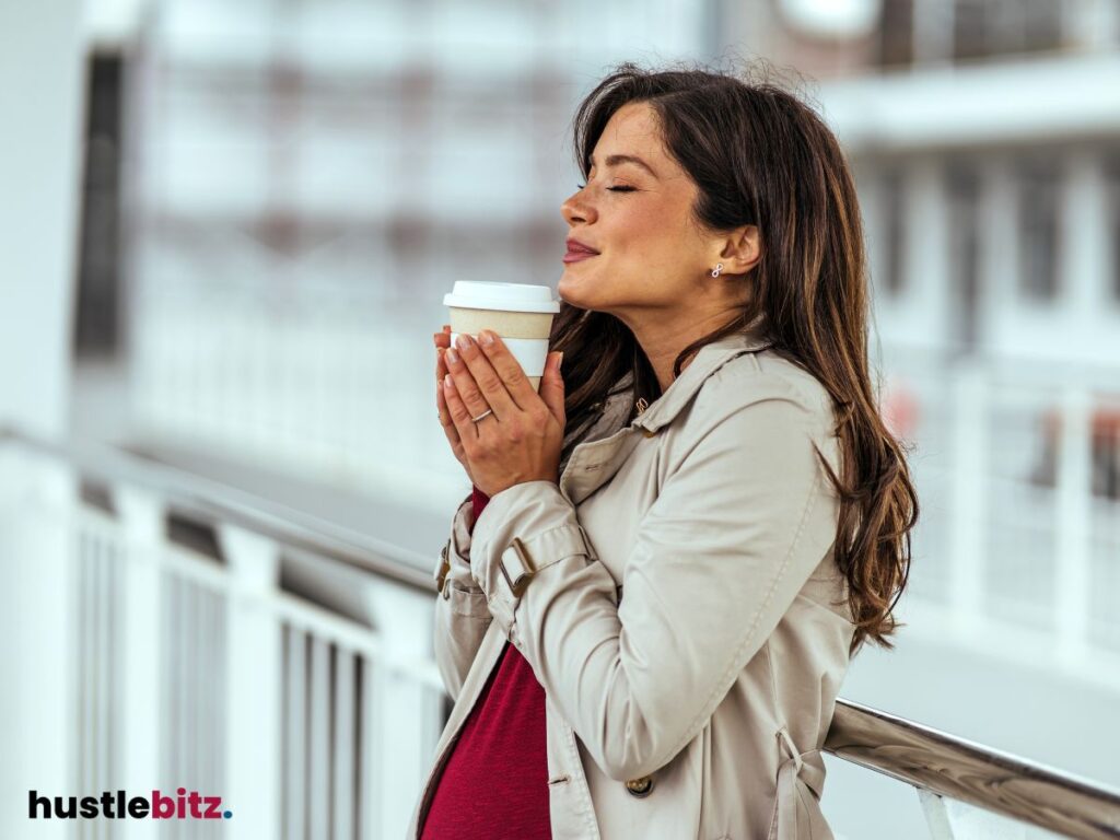 A woman enjoying a warm beverage .