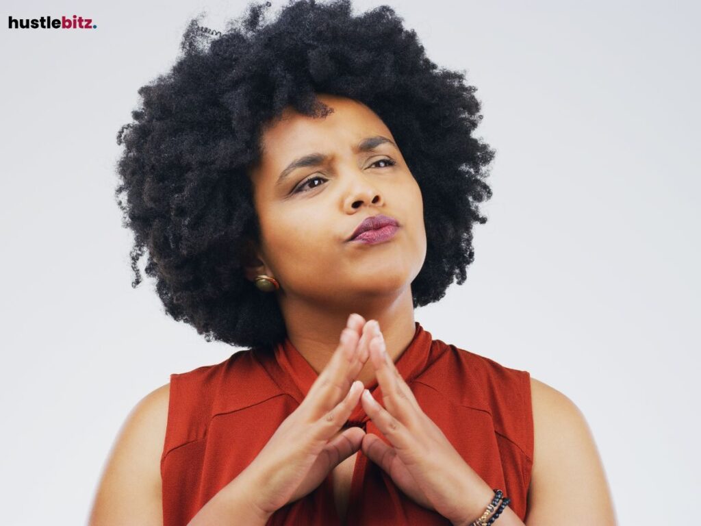 A woman with curly hair appears deep in thought.