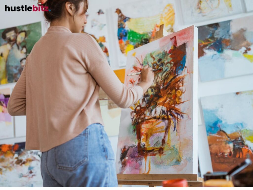 Artist painting on canvas in a studio filled with abstract artworks.