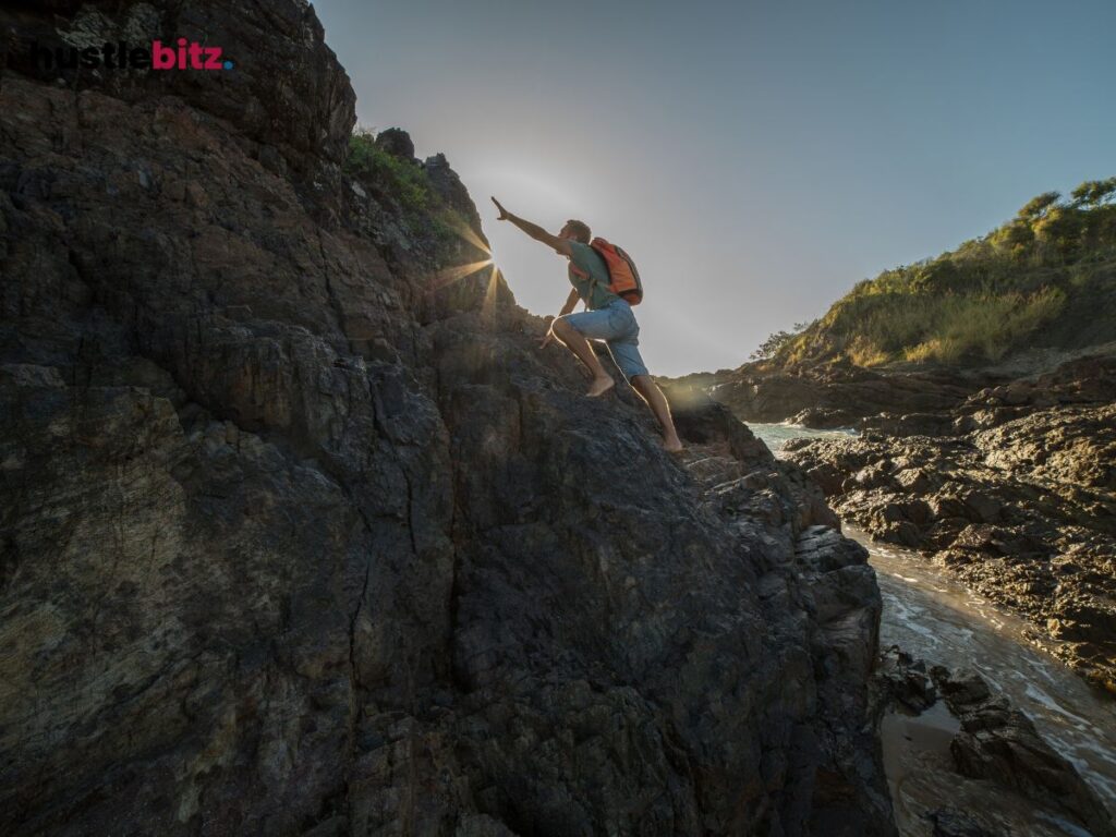 A man with bag in his back climb the mountain with full of rocks