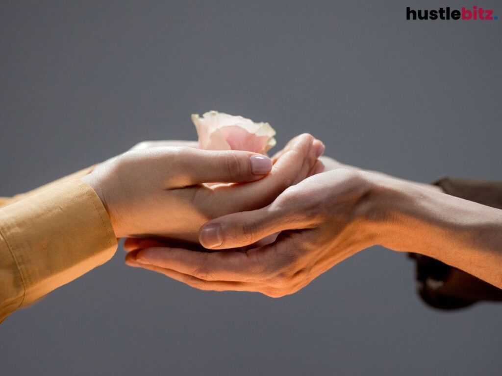 Hands holding a pink flower, showing compassion.