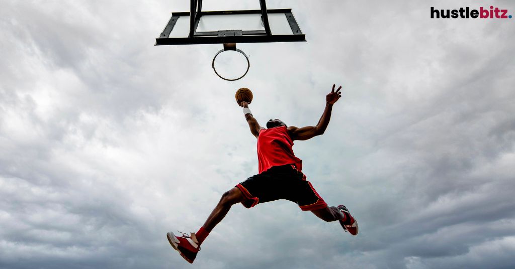 A man trying to dunk on the ring.