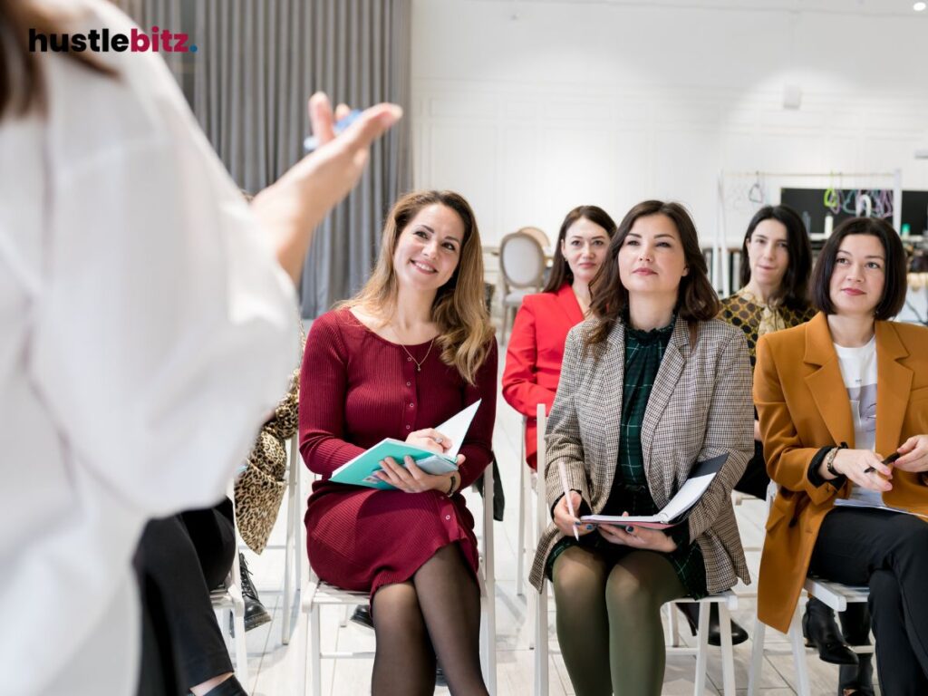 A group of women attentively listens to a speaker in a seminar.