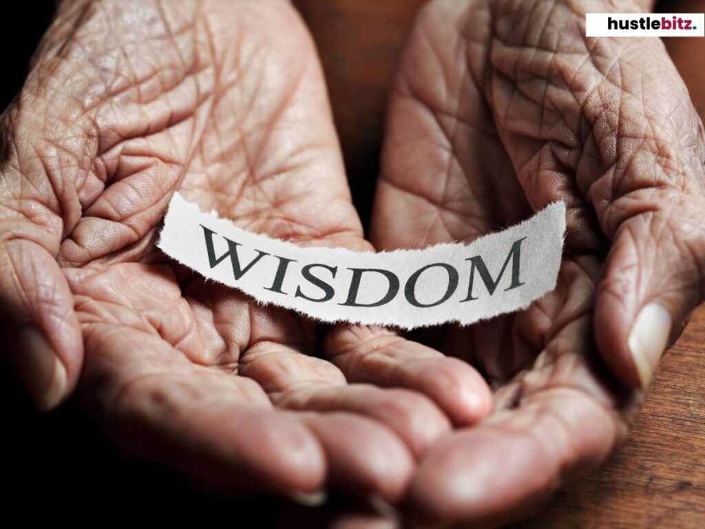 Elderly hands holding "Wisdom" paper.
