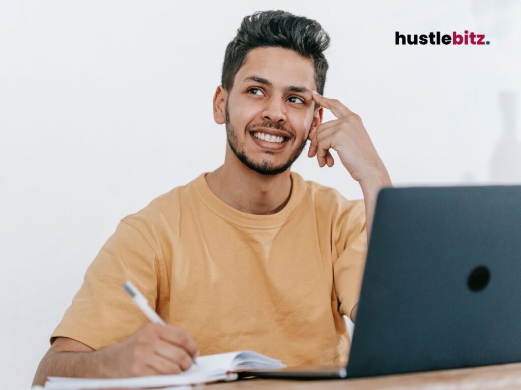A man thinking something while doing writing in front of the laptop