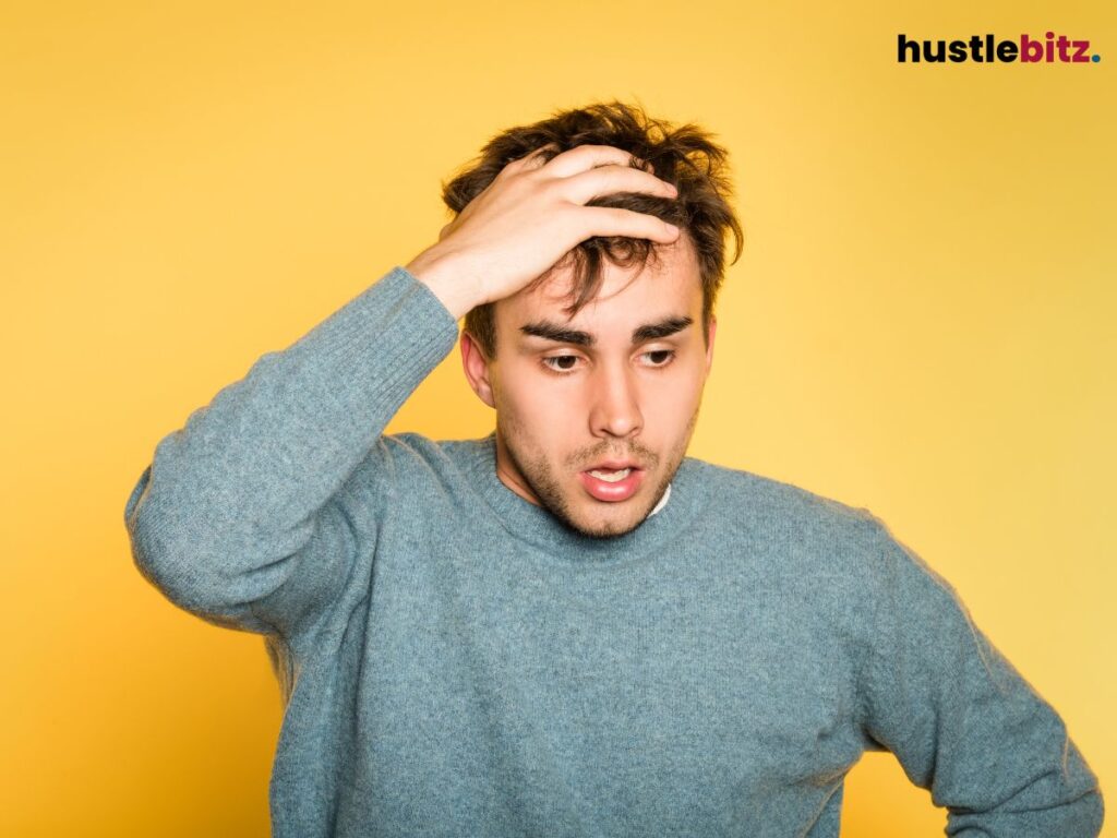 Man looking confused, his hand on his head, overwhelmed by uncertainty.