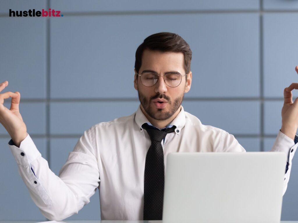 A man wearing eyeglass doing meditation inside the office