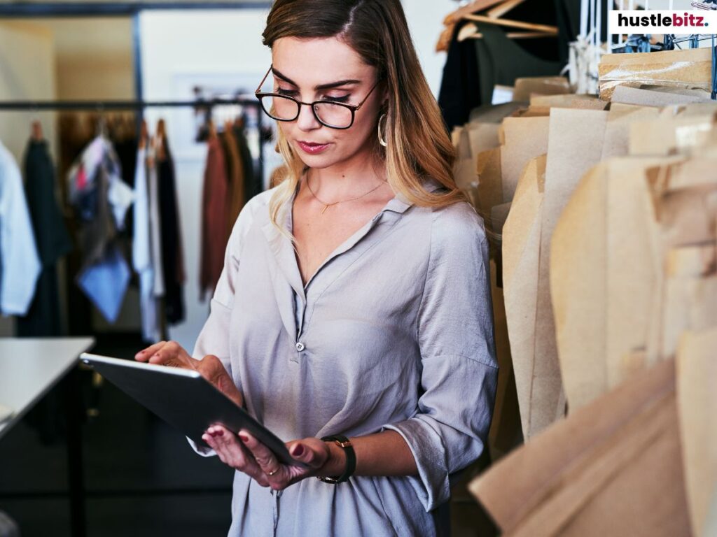 A young woman working on a tablet in a modern fashion studio.