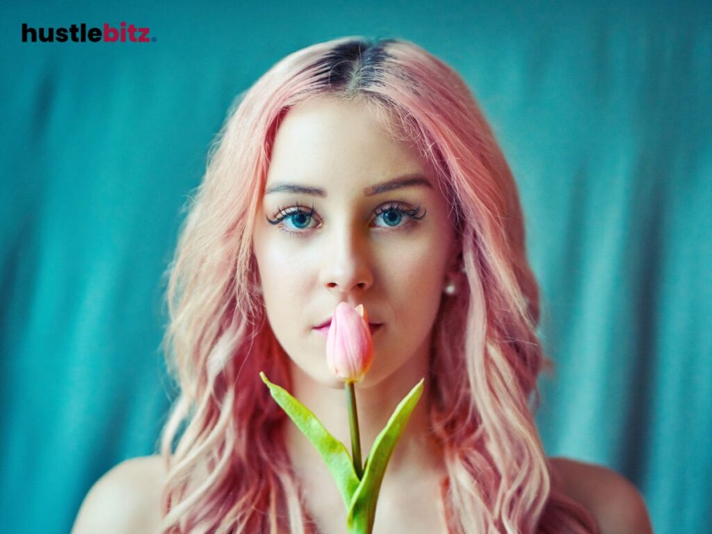 A woman covering her mouth with pink tulips.