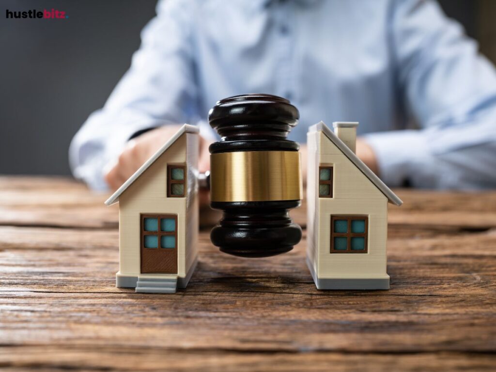 A judge's gavel separating two model houses, symbolizing decision-making.
