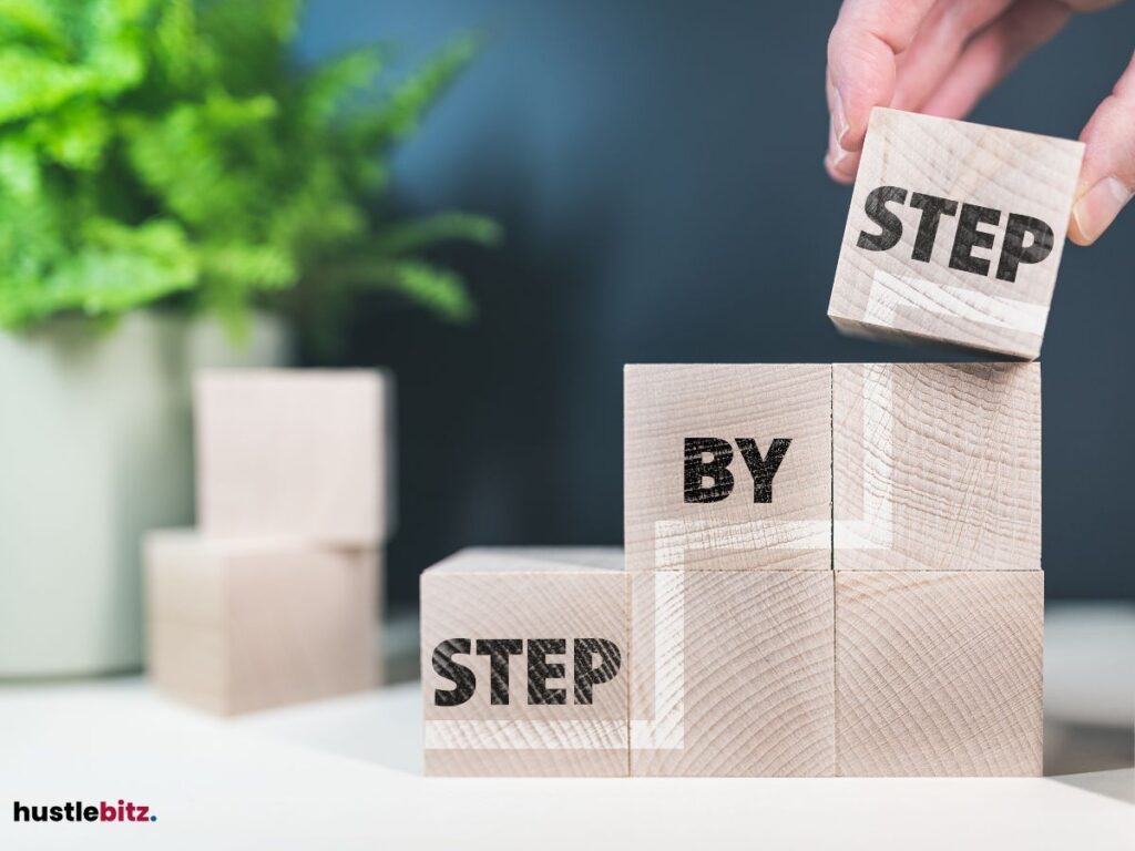 A hand building the blocks to stairs with the word "STEP BY STEP"