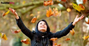 A woman smiles while raise her two hands , feel the nature