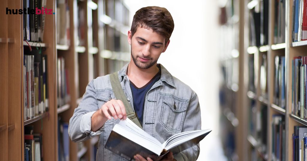 A man in a library flips through a book, focused on reading.