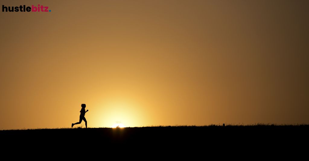 Silhouette of a person running at sunset.