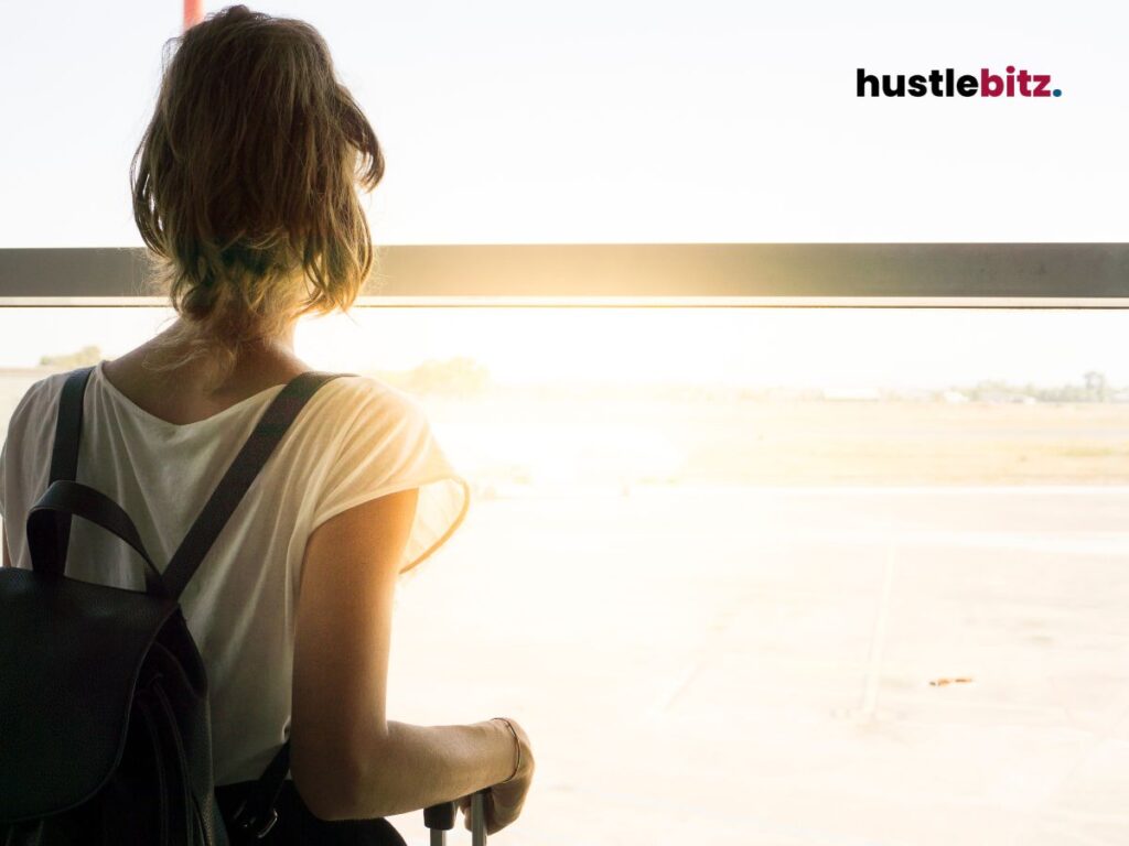 Woman looking out of a window at an airport, ready for new beginnings in her journey.