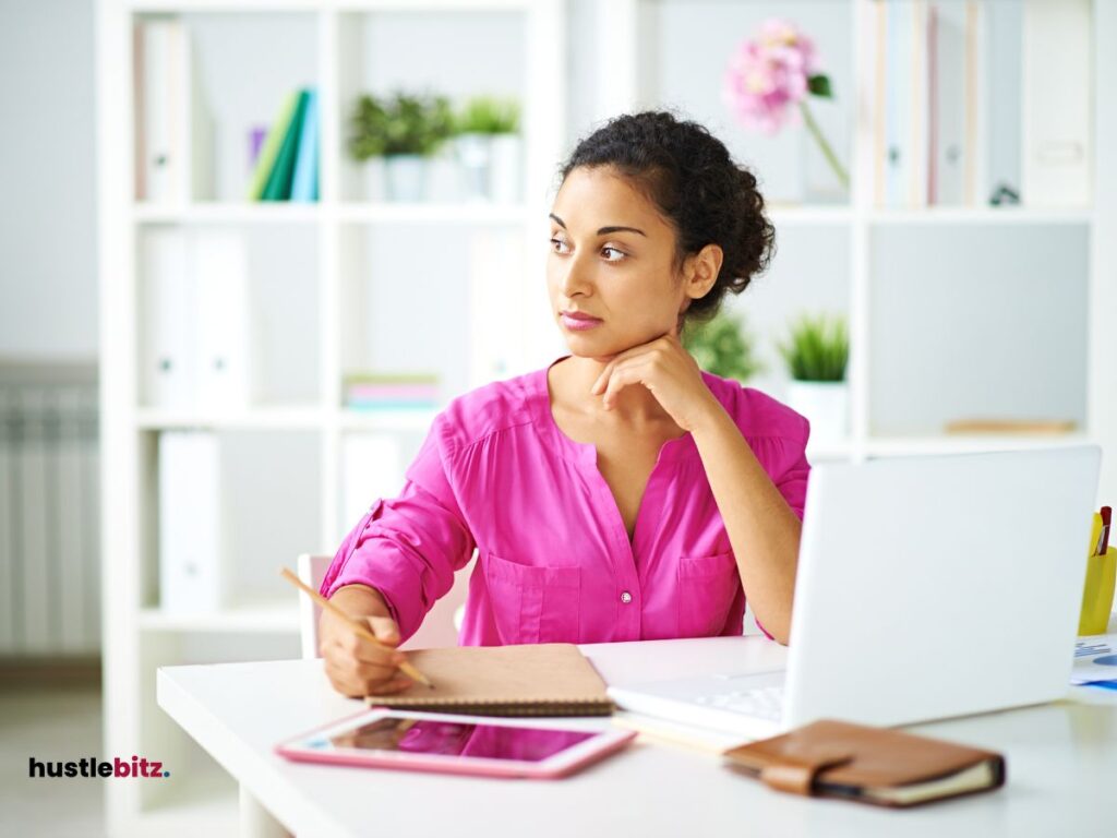 A woman sitting in the chair beside the laptop