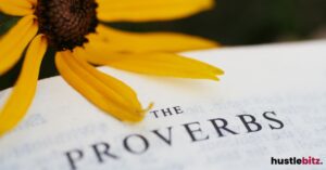 "The Proverbs" page from a book, with a yellow flower petal above.