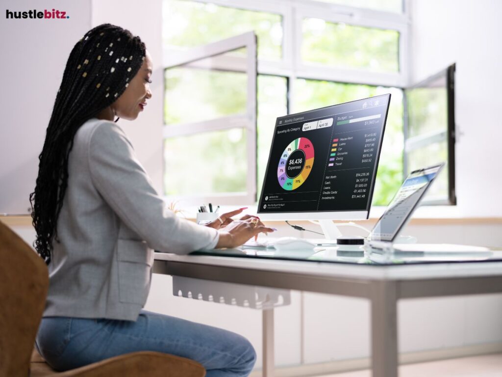 A woman facing to the monitor while typing inside the room
