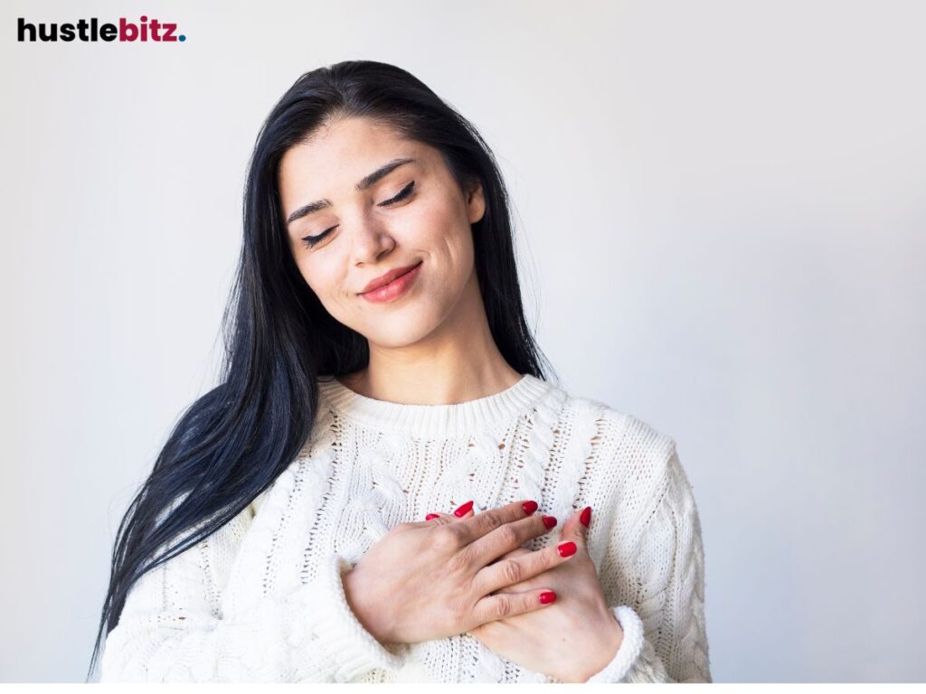 A woman smiles and hold her chest