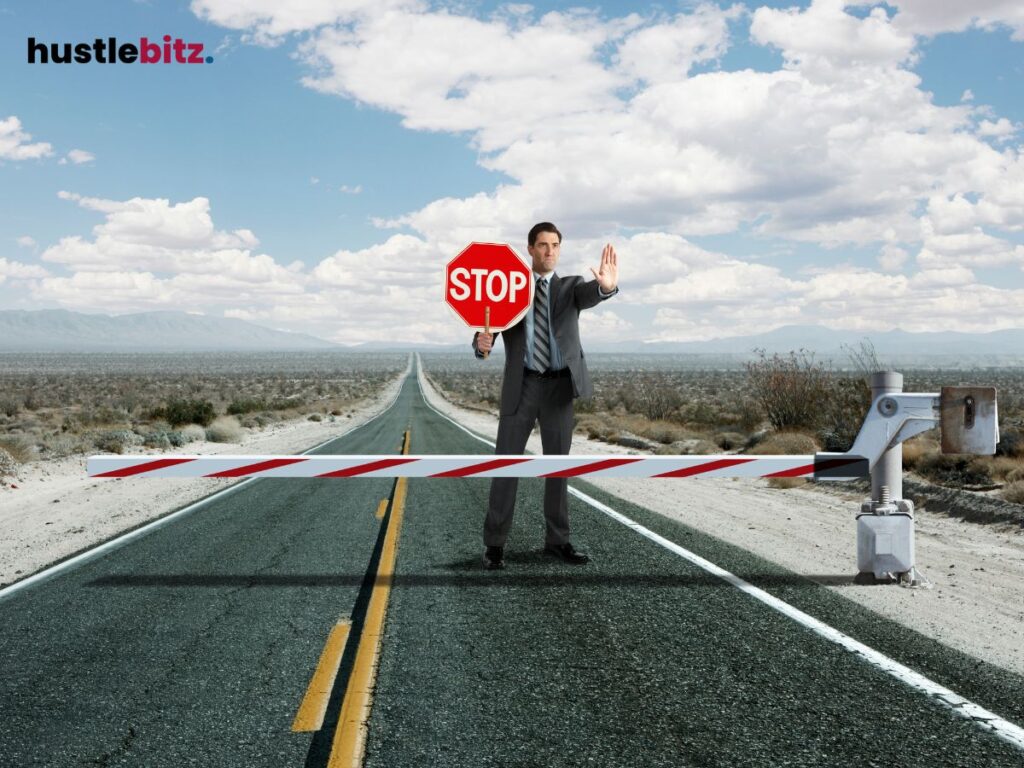 Man holding a stop sign on a deserted road, symbolizing blocking obstacles.