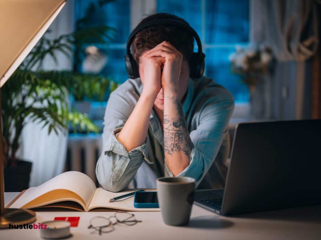 A person wearing headset and a laptop with coffee in the table