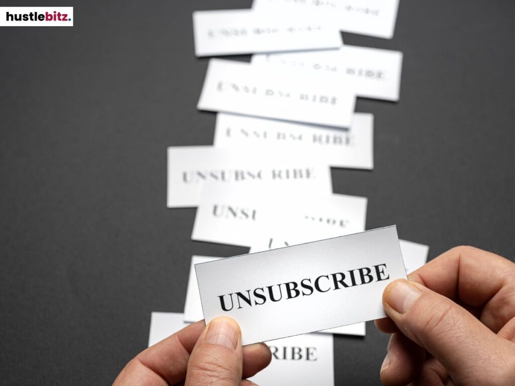 A hand holds a paper with a text "UNSUBSCRIBE" written.