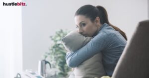 A woman hugging a pillow in an office set ting.