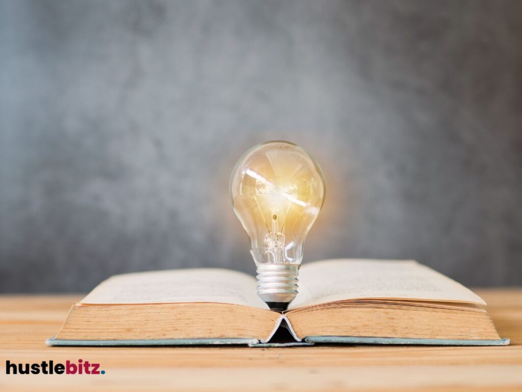 Lightbulb glowing atop an open book.