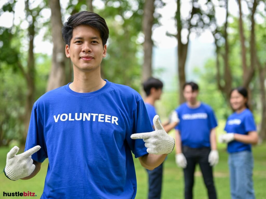 A man pointing his shirt with a word "VOLUNTEER" written on it.