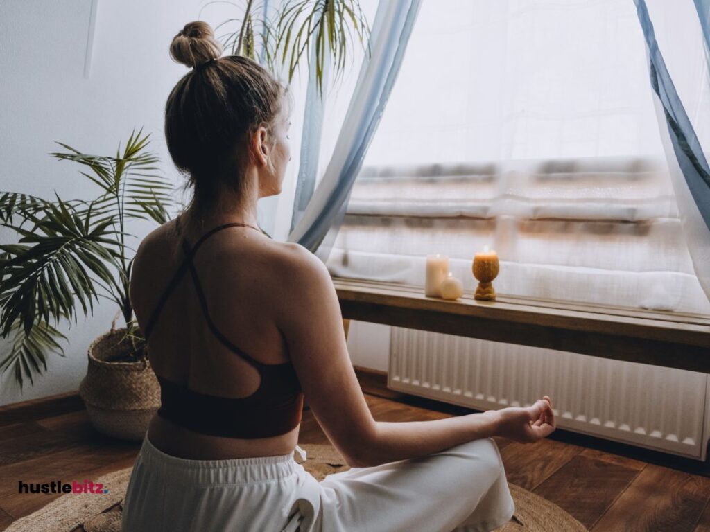 A woman doing meditation in front of the windows