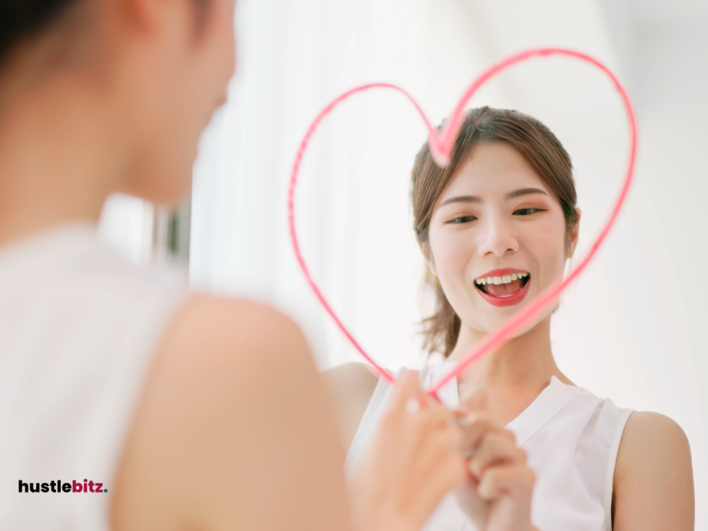 A woman drawing a heart on the mirror with her reflection.