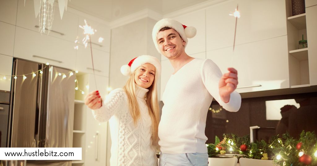 A couple wearing Christmas hats and holding sparks.