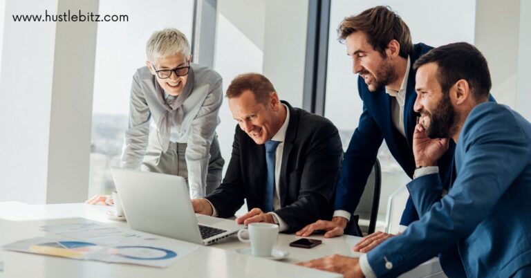 group of people smiling looking at the laptop inside the office