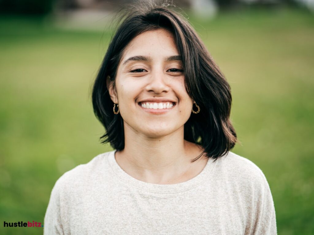 A smiling woman standing outside.