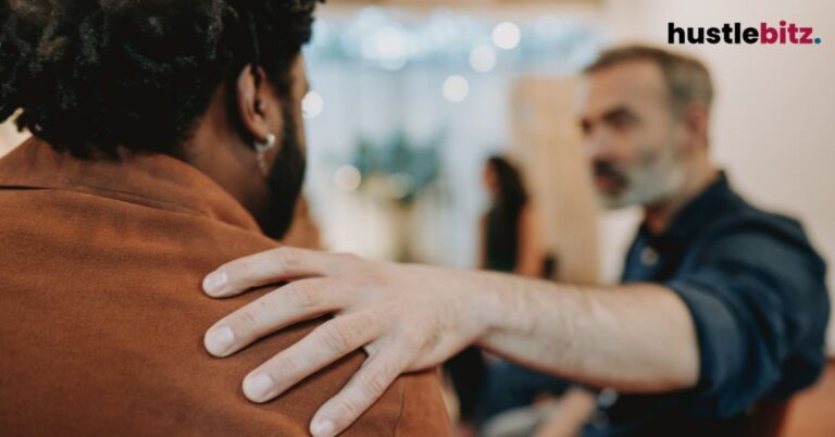 A supportive hand rests on someone’s shoulder, offering comfort and understanding.