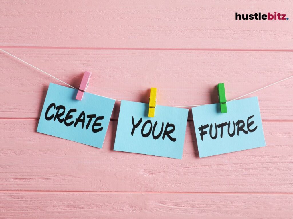 Three cards on a string read "CREATE YOUR FUTURE" against a pink background.